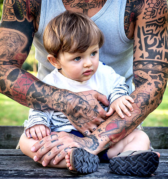 istock Tattooed Father Embracing Son 585786380