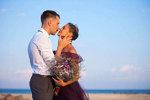 istock Young romantic couple relaxing on the beach watching the sunset 585787768