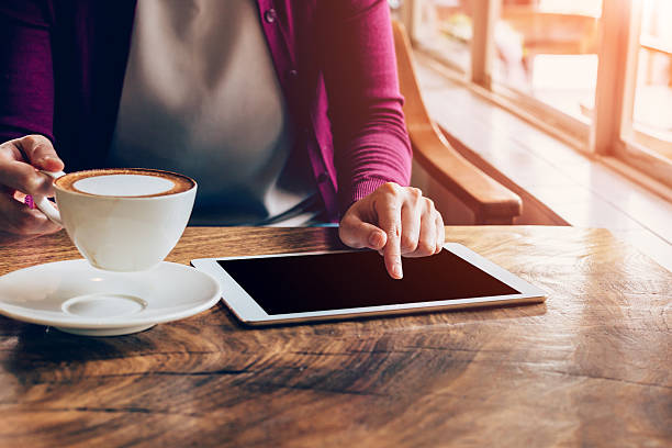 istock woman using tablet computer in coffee shop with vintage tone. 585787934