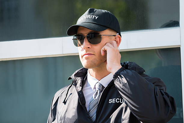 istock Young Security Guard Standing In Front Of The Entrance 585789492