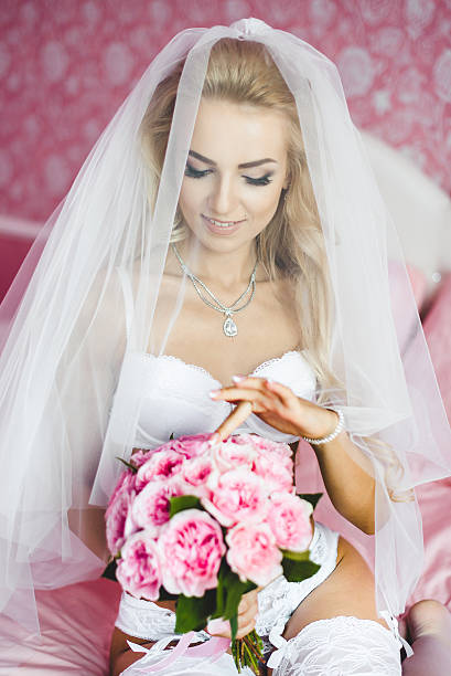 istock Beautiful bride sitting on a bed 585790004