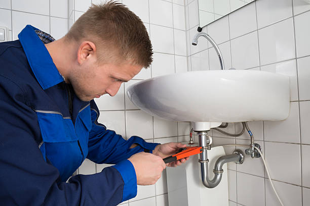 istock Male Plumber Fixing Sink In Bathroom 585790218
