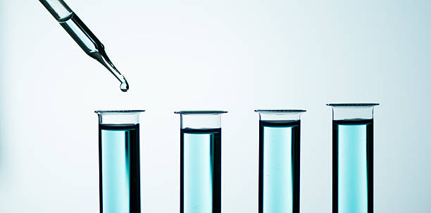 istock Liquid drop from laboratory glass pipette to test tube 585792638