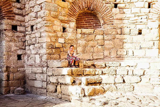 istock Girl sitting among the stones 585793590