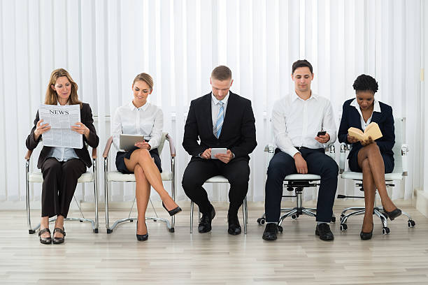 hommes d’affaires en attente d’entrevue - unemployment waiting in line waiting room interview photos et images de collection