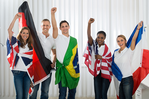 Group Of Happy Friends With Flags From Different Nations