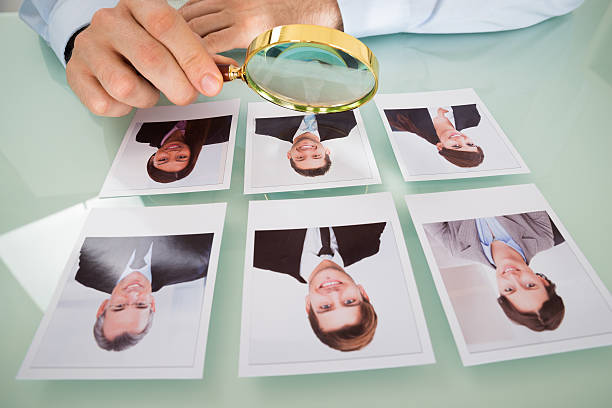 istock Person With Candidate Photograph And Magnifying Glass 585797726