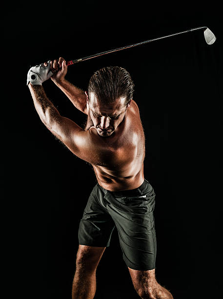 istock Shirtless Golfer Swinging On A Black Background 585798010