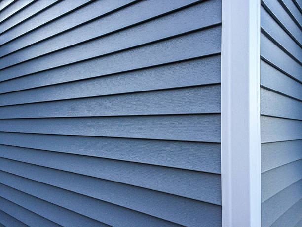 Blue Vinyl Siding Photography of new, blue vinyl siding on a home. plastic stock pictures, royalty-free photos & images