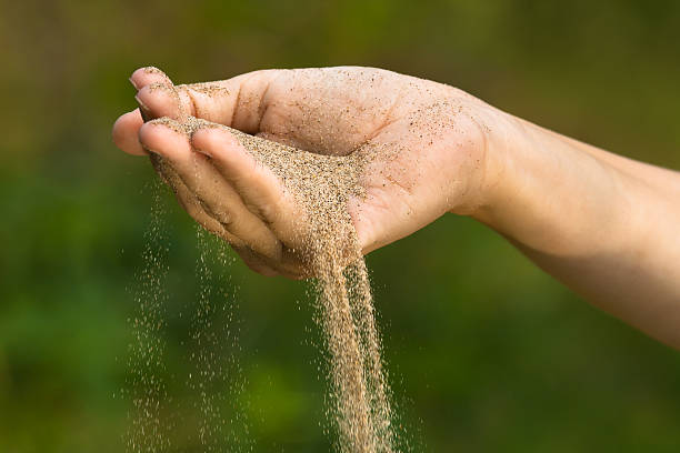 istock sand running through fingers like symbol of time 585799584