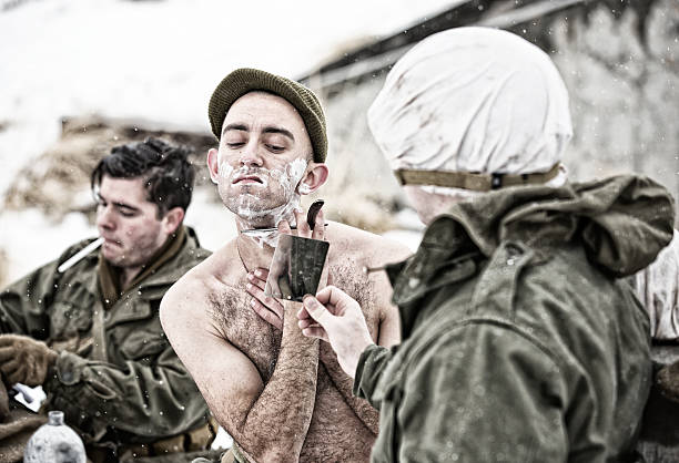 Three soldiers shaving, brushing teeth, and prepping for the day on a snowy winter morning.
