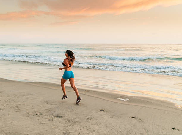 istock Hispanic Women Running At The Beach At Sunset 585802074
