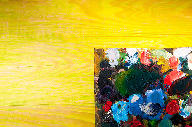 istock Painting palette on colored wooden background 585803364