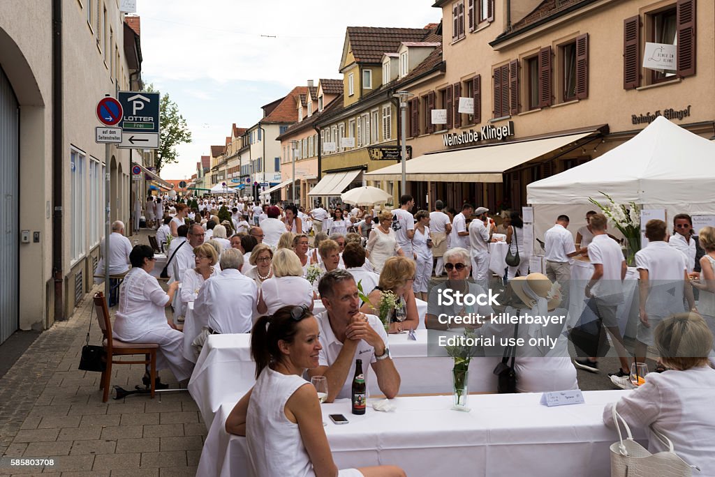 Le Diner En Blanc - the white dinner Ludwigsburg, Germany - July 30, 2016: People are enjoying le diner on blanc – the white dinner – where all guests are asked to dress in white, dining at white tables in Ludwigsburg near Stuttgart, Germany. Dinner Stock Photo