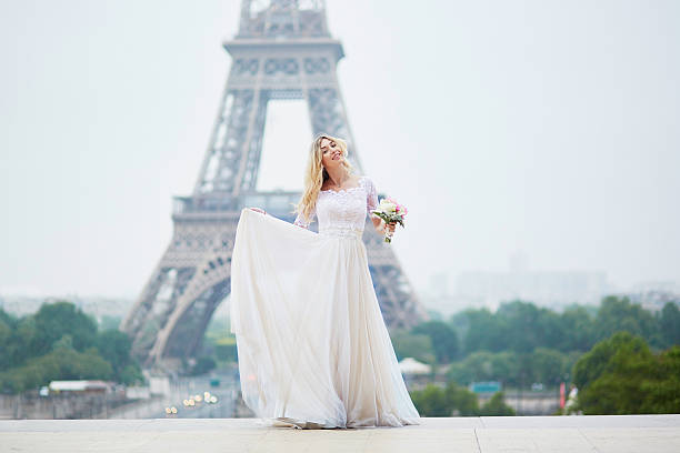 hermosa novia en vestido blanco cerca de la torre eiffel - honeymoon wedding paris france bride fotografías e imágenes de stock