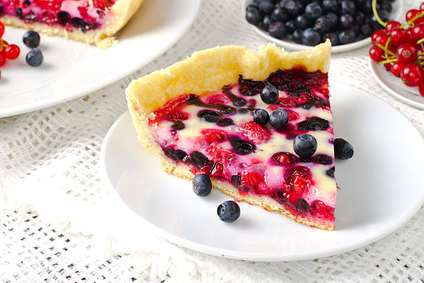 Mix berry tart, pie, cake with raspberries, bilberries, bluberries, red currant and cream on white background, toned