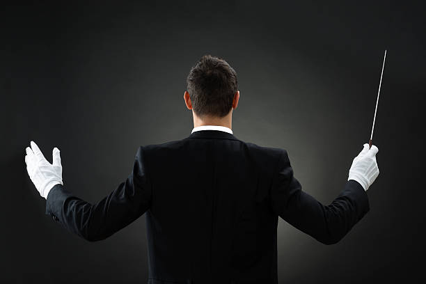 istock Rear View Of Music Conductor Holding Baton 585804584