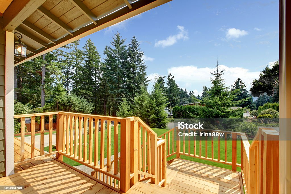 Wooden walkout deck with patio area Wooden walkout deck with patio area overlooking backyard. Northwest, USA Railing Stock Photo