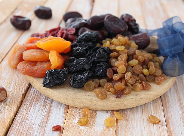 istock Dried apricots, dates, raisins, vintage wooden background, selective focus 585805322