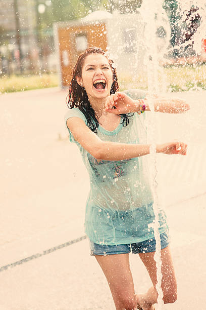 istock Girl having fun in a water fountain 585807622