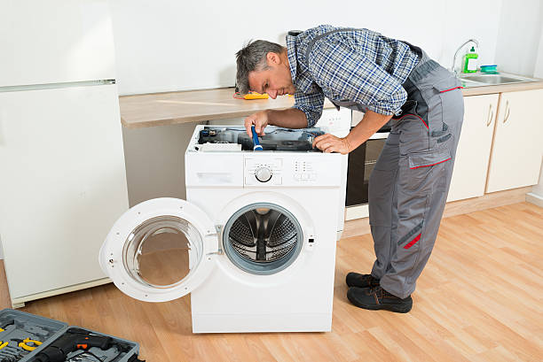 разнорабочий проверка стиральная машина с фонариком - repairing appliance clothes washer repairman стоковые фото и изображения