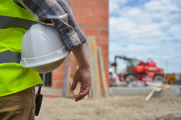 istock Worker holding a helmet with background of construction site. 585809778