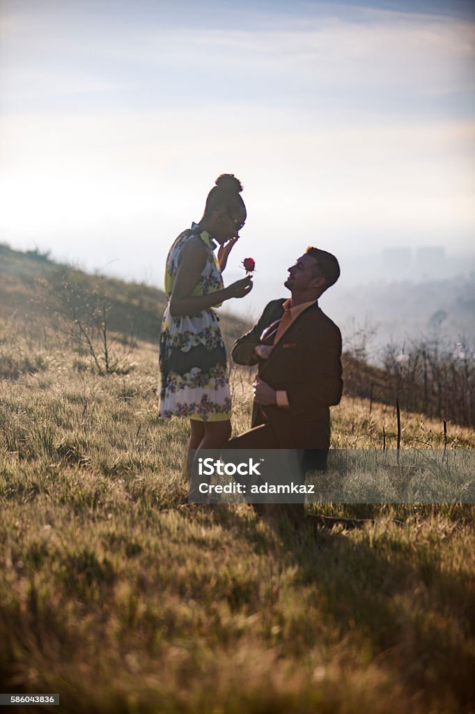 African American Woman and Caucasian Man get Engaged An attractive young African American Woman and a Caucasian Man get engaged on a mountain. Engagement Stock Photo