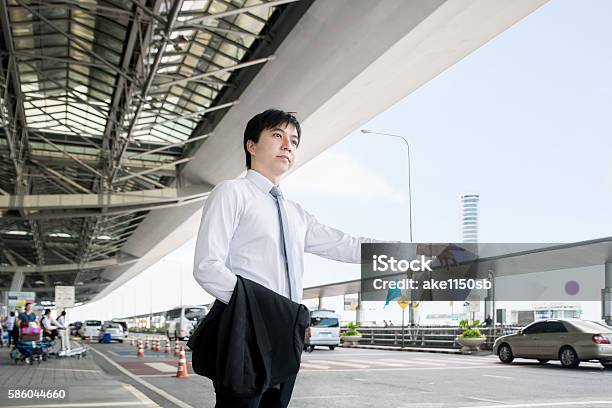 Young Asian Businessman Calling Taxi At The Airport Stock Photo - Download Image Now