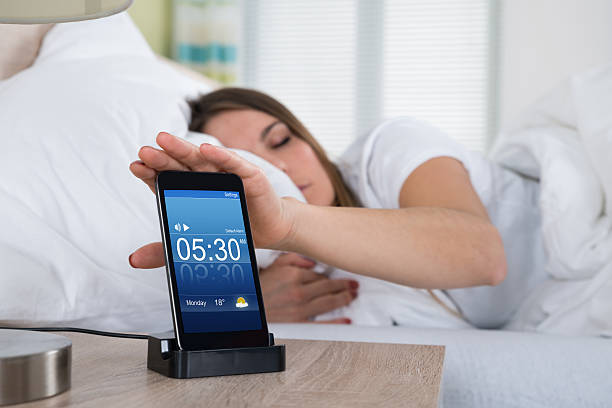 istock Woman Snoozing Alarm On Mobile Phone Screen 586044904
