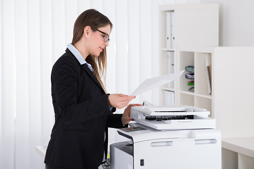 Young Beautiful Businesswoman Using Copy Machine In Office