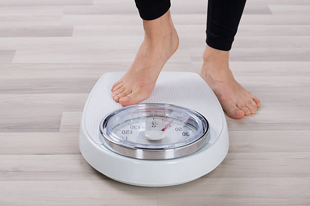 istock Person Standing On Weighing Scale 586045126