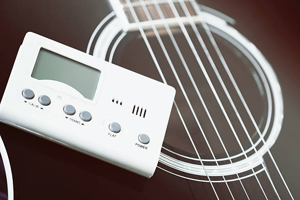 istock Guitar and tuner for musical instruments 586045486