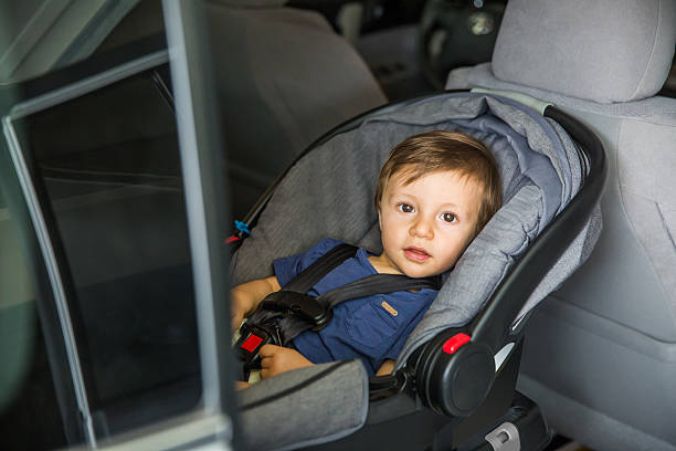 Baby Seat Car Safety Baby strapped in to baby seat of a car and looking at view. Baby is 10 months old. seat belt photos stock pictures, royalty-free photos & images