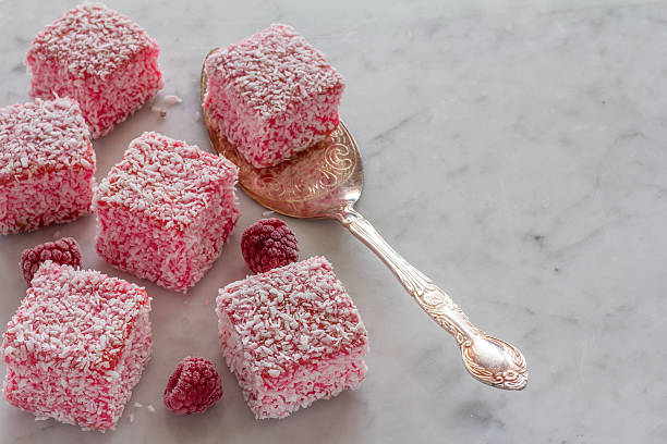 lamingtons roses avec framboises sur marbre - lamingtons photos et images de collection