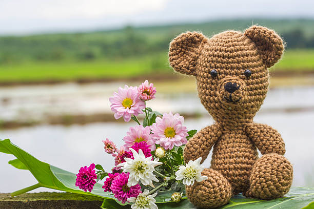 istock Single bear doll and flowers on nature background 586049210