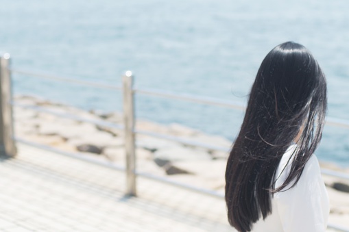 Tiro trasero de la mujer japonesa una vista del mar photo