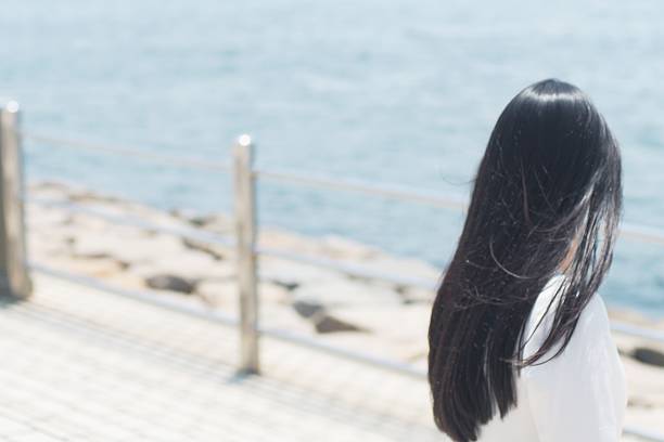 plan arrière d’une femme japonaise une vue sur la mer - cheveux noirs photos et images de collection
