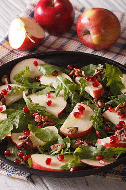 istock salad with red apples, pomegranate, walnuts and arugula closeup. 586049634