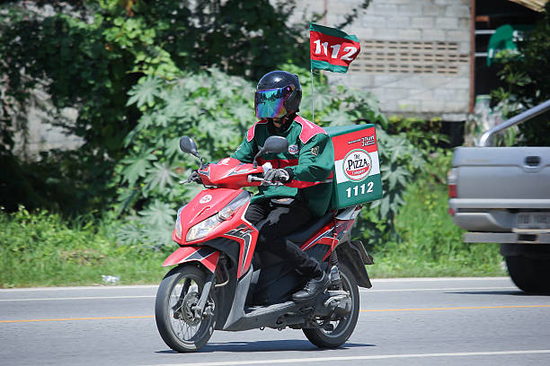 l’homme de service de livraison monte un motercycle - pizza hut asia pizza restaurant photos et images de collection