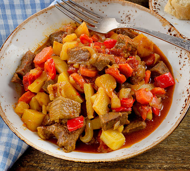 istock Meat stew with vegetables on old wooden table. 586050294