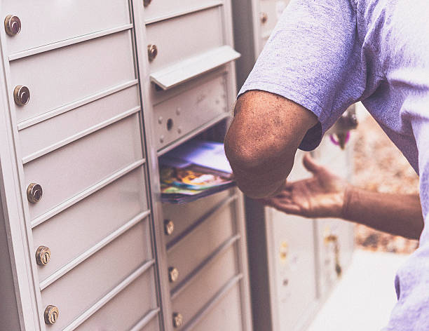 kaukaski mężczyzna pobierający pocztę ze skrzynki pocztowej - mailbox mail junk mail opening zdjęcia i obrazy z banku zdjęć