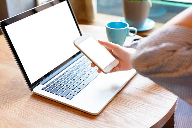 istock Young woman using smartphone and laptop in cafe. 586050728