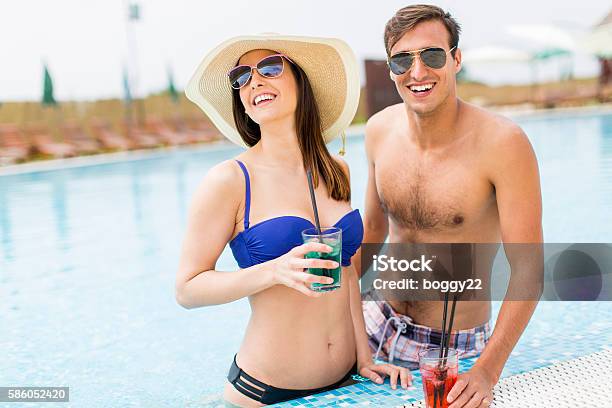 Young Couple By The Pool Stock Photo - Download Image Now - Adult, Adults Only, Alcohol - Drink