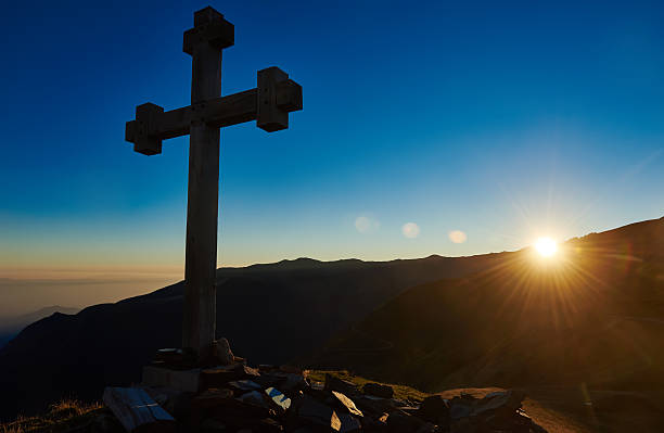 istock cross sign on the mountain peak pass at sunset 586052572