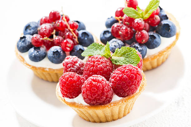 istock mini tarts with cream and fresh berries on white background 586053558
