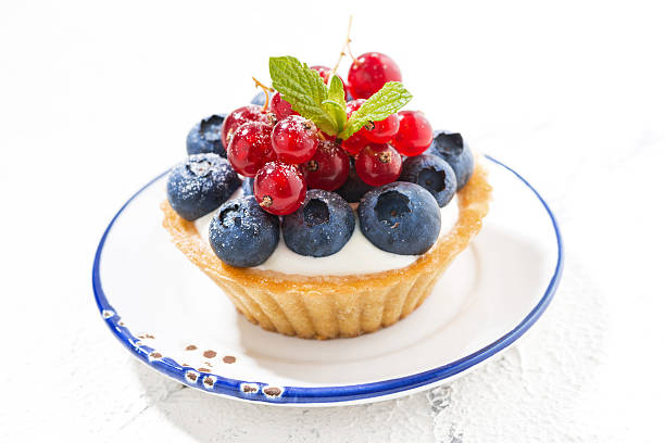 istock mini tart with cream and berries on white plate 586053616