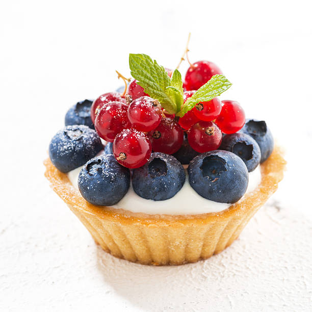 istock mini tart with cream and berries on white background, closeup 586053632