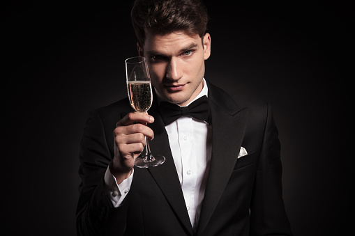 Handsome elegant man offering you a glass of champagne.