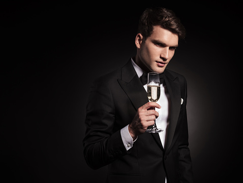 Attractive young man holding a glass on wine in his hand.
