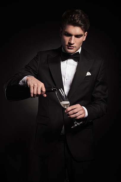 istock Young elegant man pouring wine in a glass 586054458